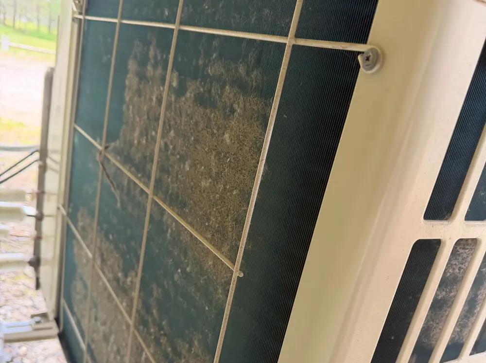 Outdoor condenser coil clogged with debris before cleaning